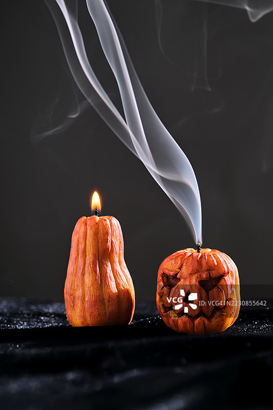 冒烟的南瓜灯蜡烛，黑色背景中的火焰图片素材