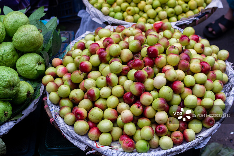 新鲜的番石榴和苹果在市场摊位上展示图片素材