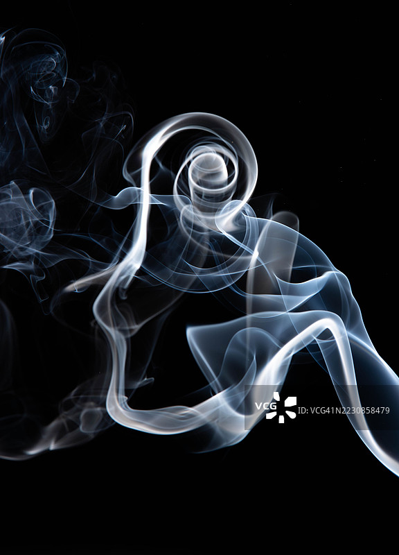 黑色背景上的抽象旋转烟雾图案图片素材