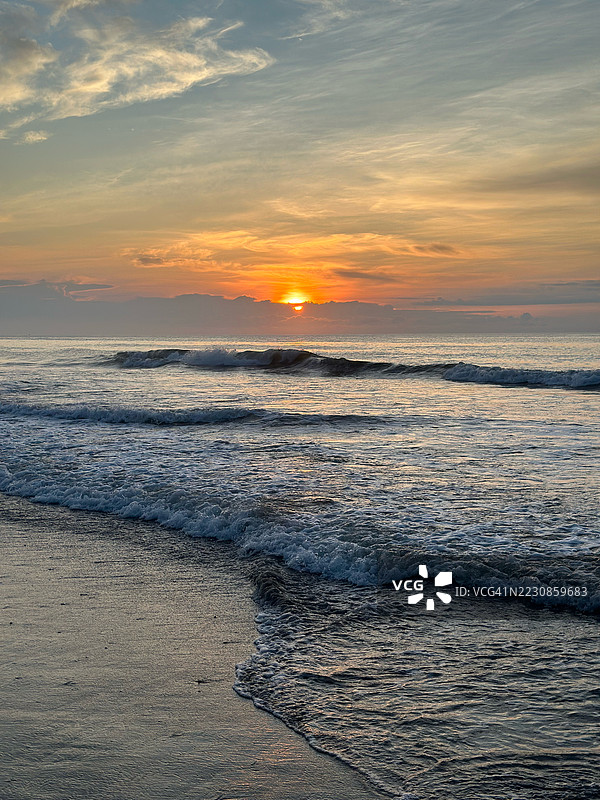 海上日落，波浪拍打着海岸图片素材