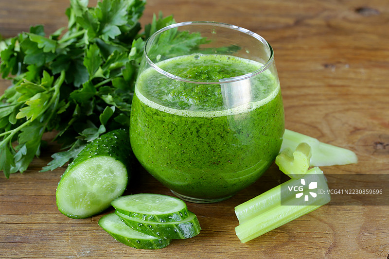 新鲜的黄瓜芹菜绿色果昔放在木桌上图片素材