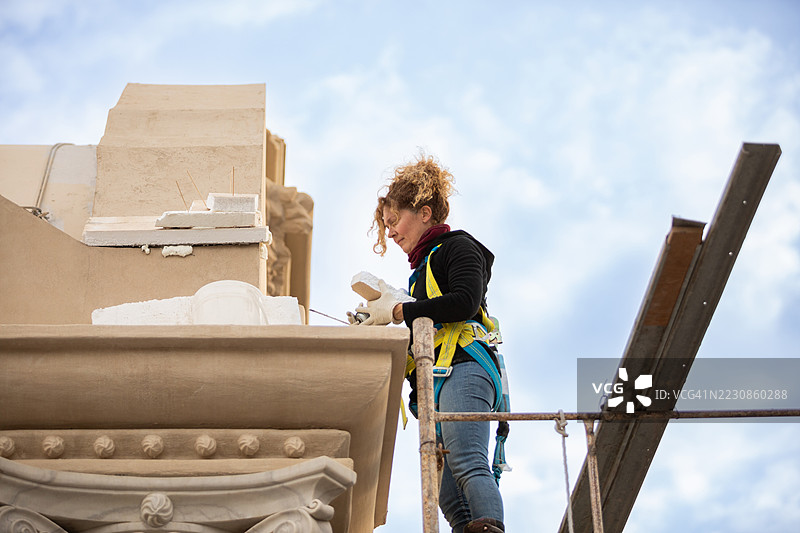 女性艺术家正在修复文艺复兴建筑的外立面图片素材