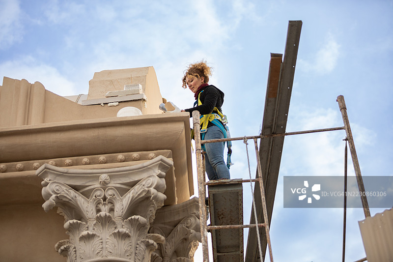 女性艺术家正在修复文艺复兴建筑的外立面图片素材