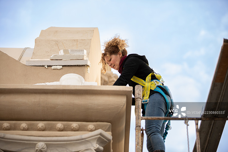 女性艺术家正在修复文艺复兴建筑的外立面图片素材