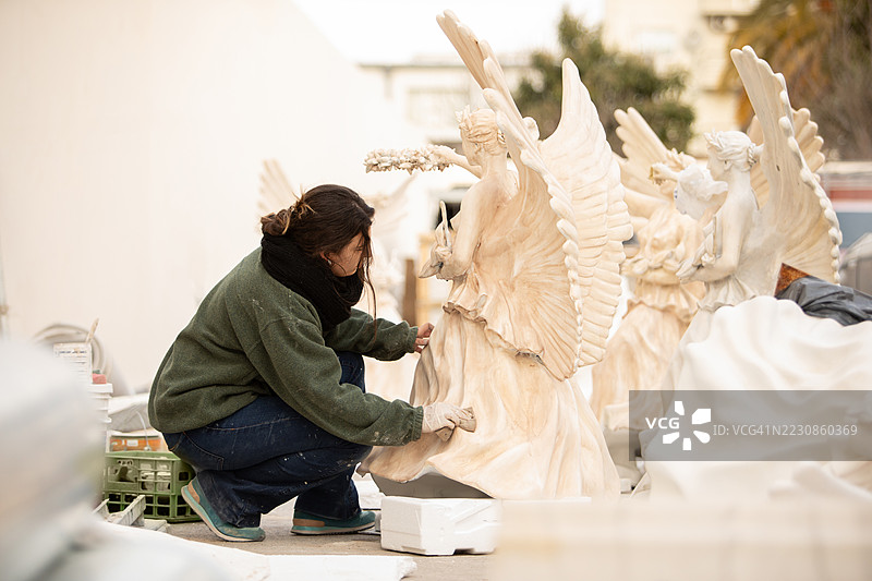 女性艺术家修复文艺复兴时期的天使雕塑图片素材