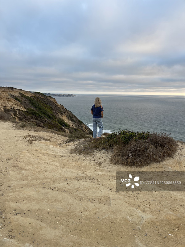 女性站在海岸小径上图片素材