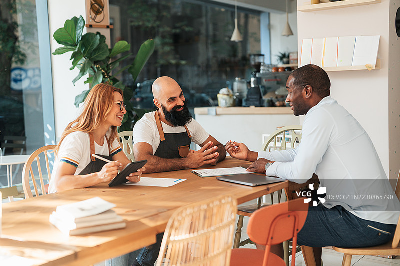 咖啡店老板与员工讨论工作流程图片素材