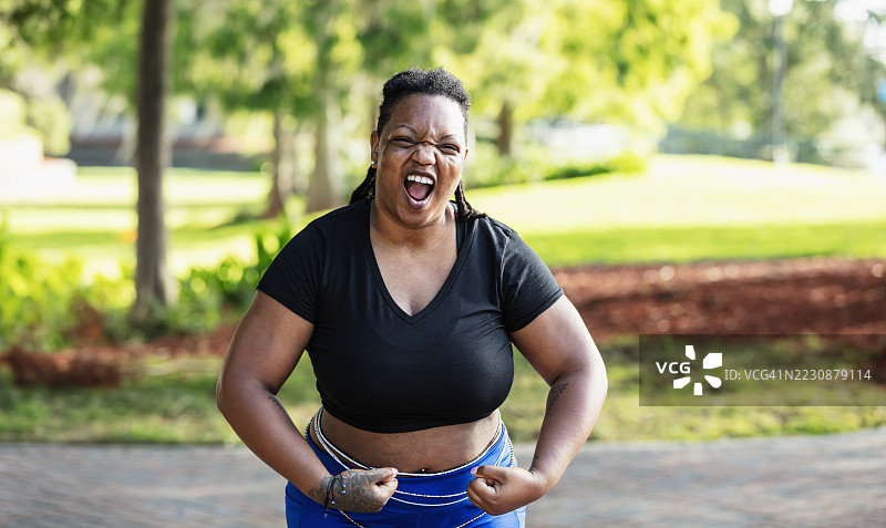 黑人女性在户外顽皮地展示她的二头肌图片素材