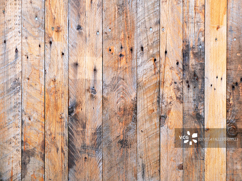 棕灰色木栅栏的特写,表面有锈蚀,螺丝清晰可见。法国上萨瓦省埃维昂莱班,阳光照射,自然色彩。图片素材