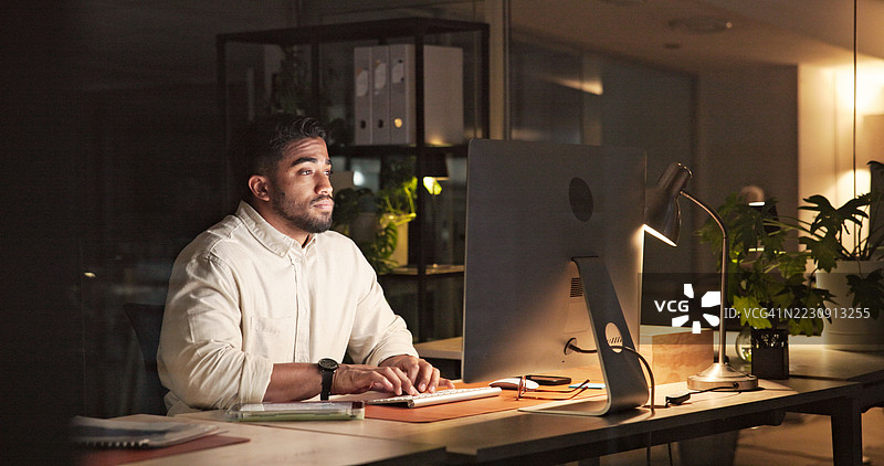 专注的专业人士在现代办公室桌前加班图片素材