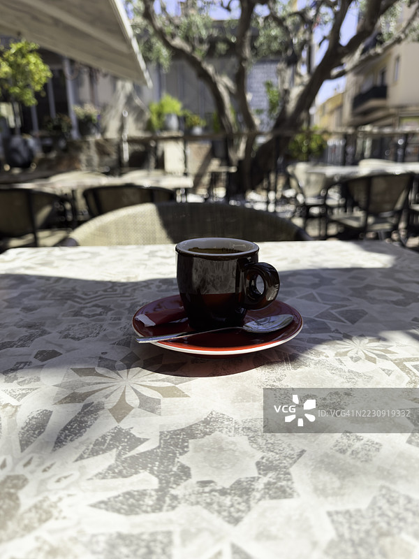 春天普罗旺斯酒吧里咖啡杯的垂直特写视图。图片素材