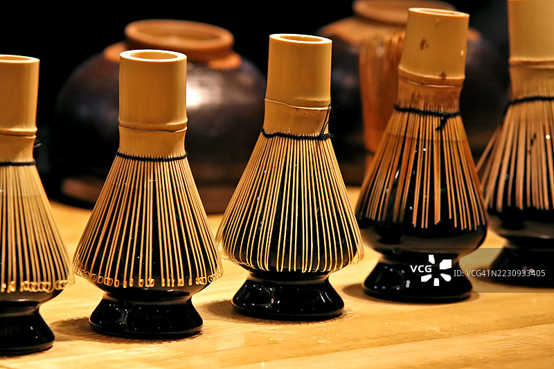 传统的茶筅，细致的竹刷毛和抛光的底座精美制作，突显了这些为仪式性抹茶准备而设计工具的精致与复杂的艺术性。图片素材