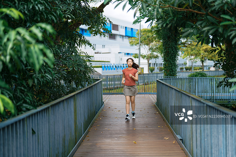 亚洲少女在公园里奔跑图片素材