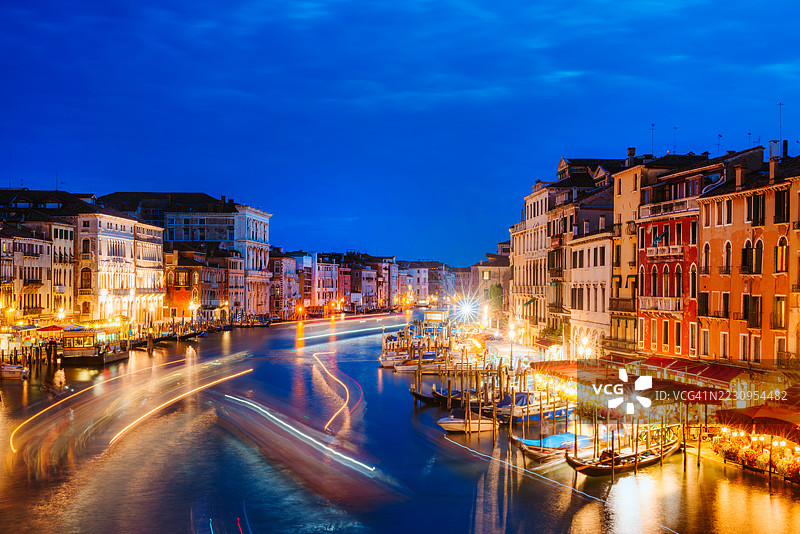 威尼斯大运河的迷人夜景，灯光照亮的外立面和贡多拉图片素材