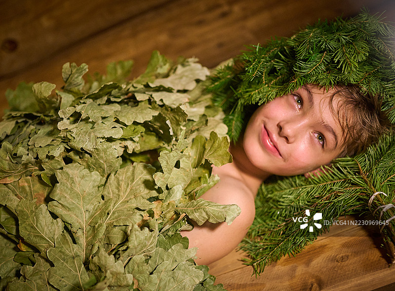 这个青春期前的男孩正在接受用橡木和冷杉扫帚进行的水疗护理。图片素材
