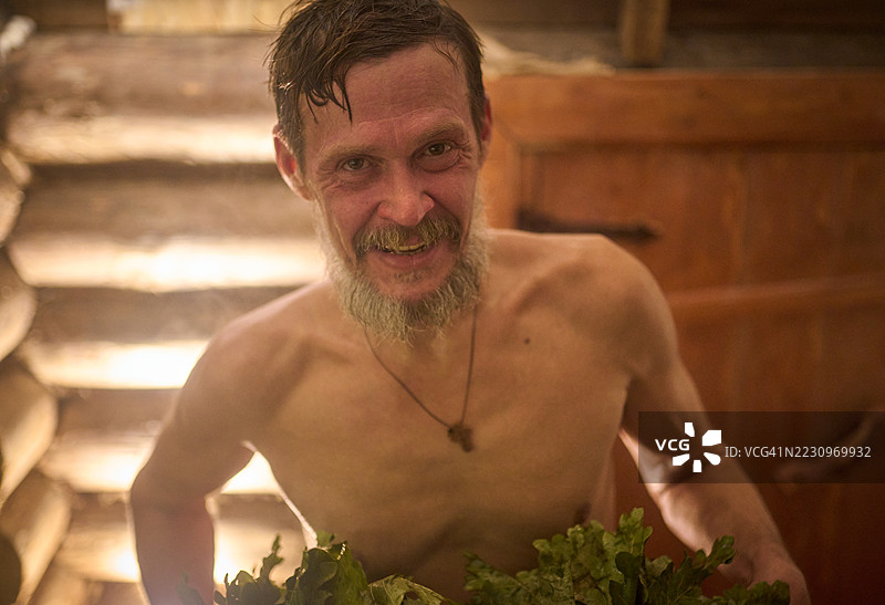 成熟的胡子男人正在浴室（蒸汽房）里蒸汽浴。图片素材