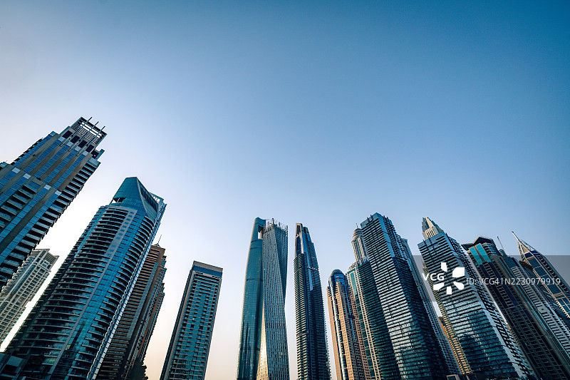 迪拜码头水岸旁的现代摩天大楼在晴朗的蓝天下图片素材