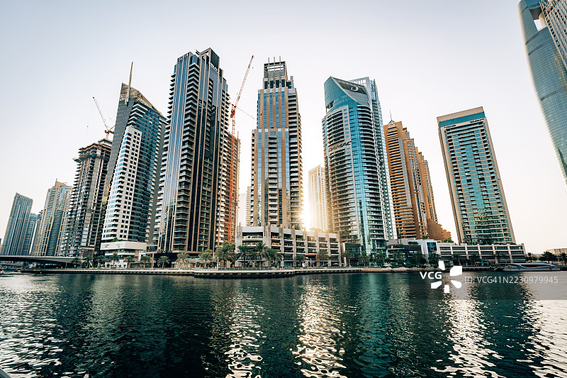 迪拜码头，阿拉伯联合酋长国的现代摩天大楼在日落时分沿水岸而立图片素材