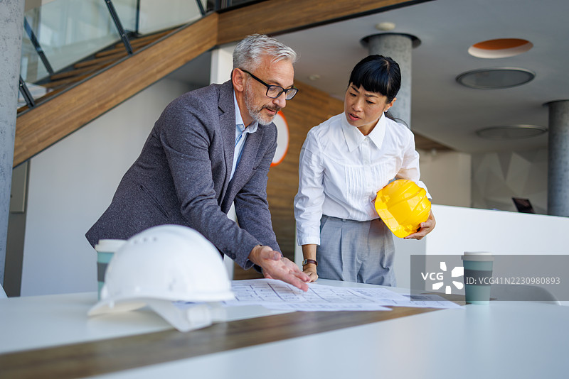 建筑师在现代办公室审查蓝图图片素材