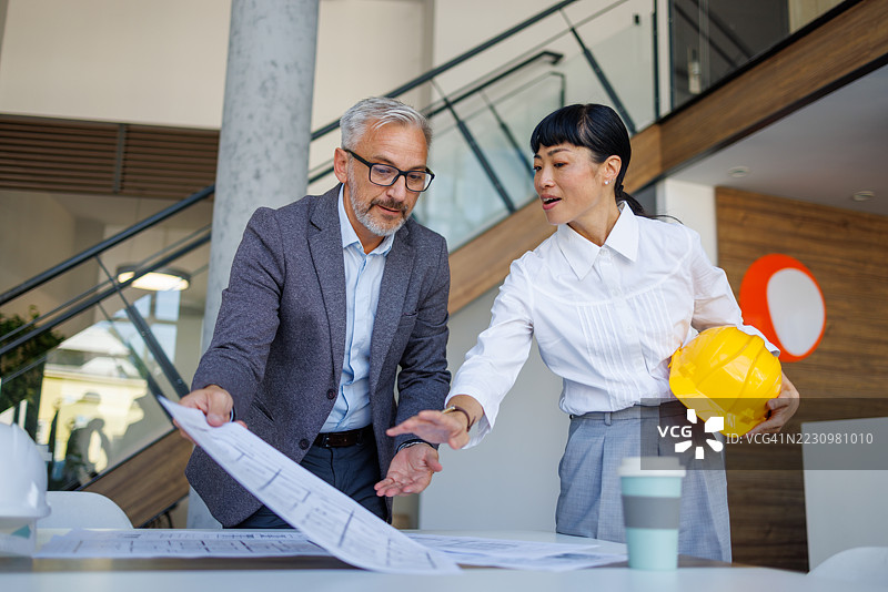 建筑师在办公室查看蓝图图片素材