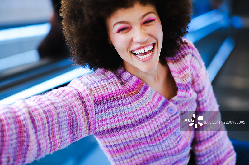 穿着色彩缤纷毛衣的非洲裔女性在元宇宙灵感的数字世界中。图片素材