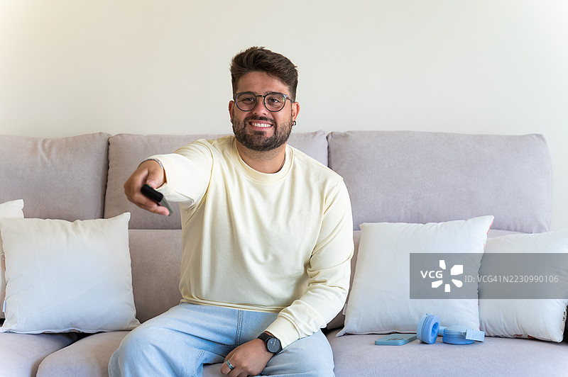 男人看电视并握着遥控器图片素材