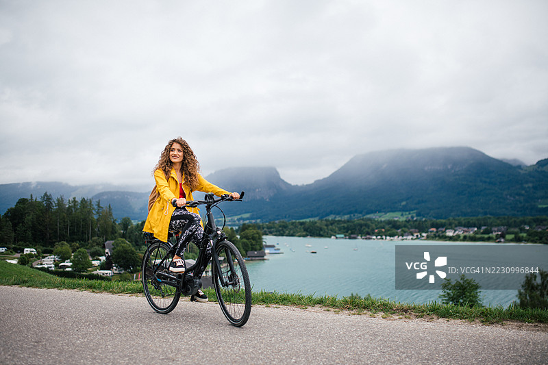 独自女性旅行者在美丽的自然中骑自行车。图片素材