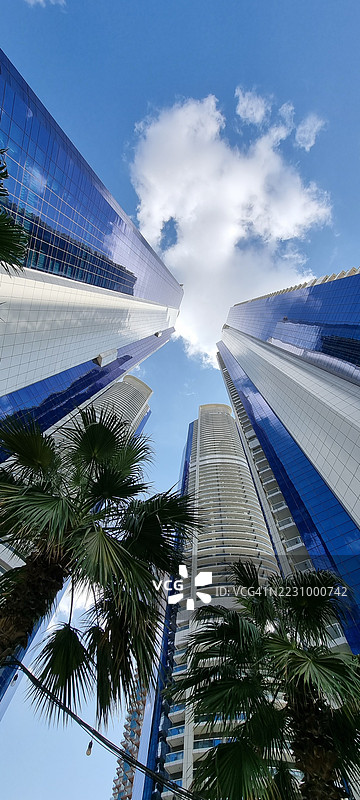 低角度视图的摩天大楼与蓝天，迪拜，阿拉伯联合酋长国图片素材