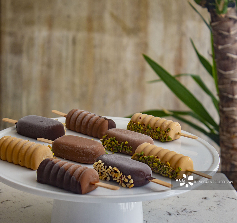 白盘上的各种巧克力和开心果冰淇淋棒图片素材