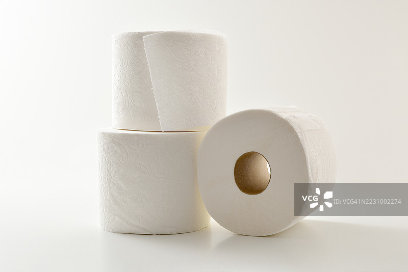 三卷卫生纸叠放在白色背景上图片素材
