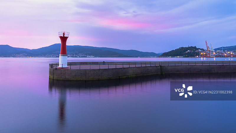 日落时分的灯塔与绚丽的天空倒影图片素材