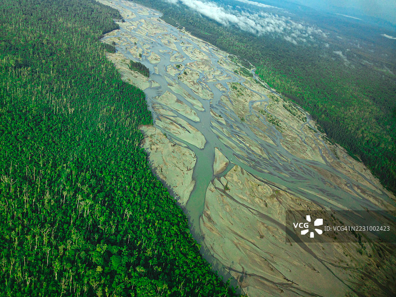 河流蜿蜒穿过郁郁葱葱的森林的鸟瞰图图片素材