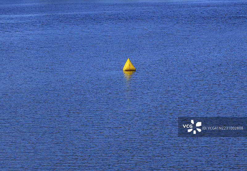 黄色浮标漂浮在平静的蓝色水面上图片素材
