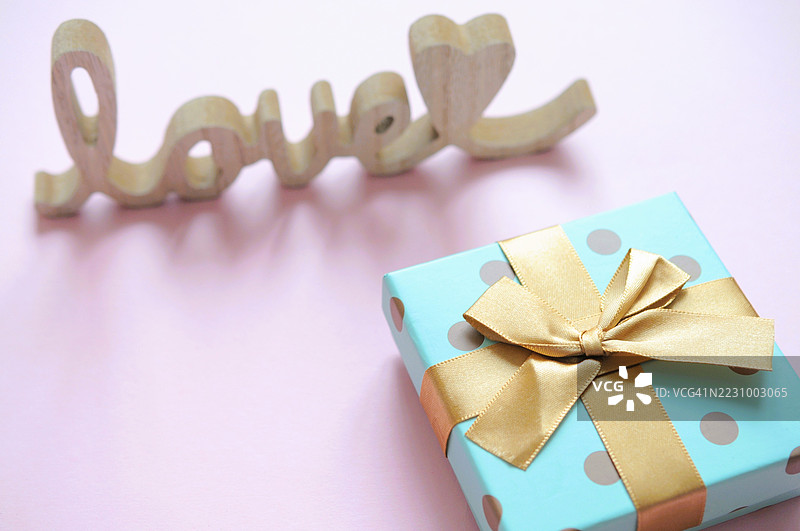 粉色背景上的金色丝带礼品盒图片素材