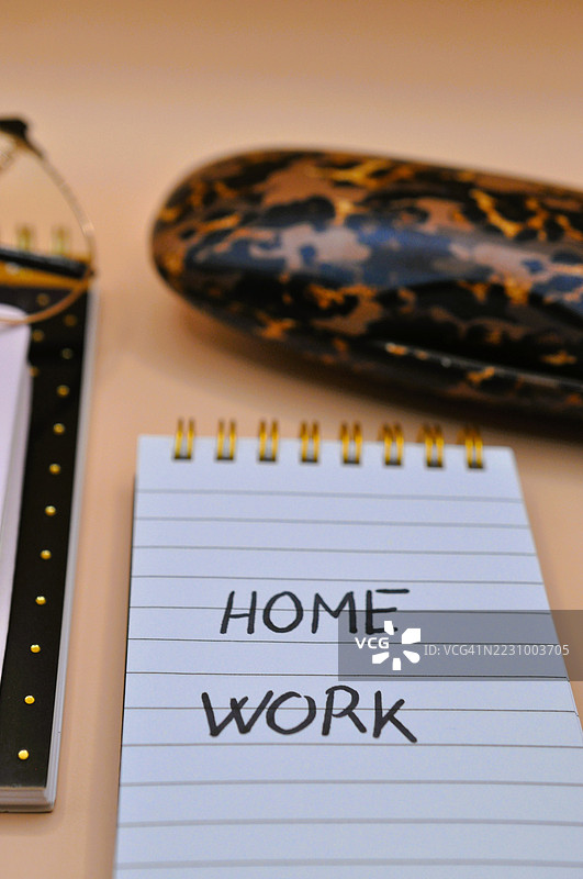 桌子上特写的笔记本，上面写着“家庭作业”字样图片素材