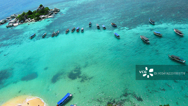 热带岛屿附近停泊的船只鸟瞰图，印度尼西亚图片素材