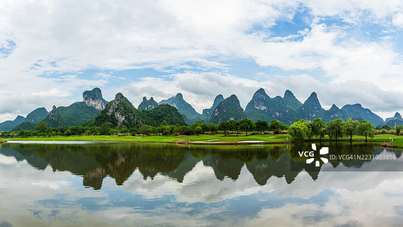 宁静的湖泊映照着喀斯特山脉，天空多云，中国图片素材