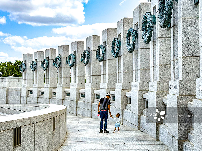 父亲和孩子在华盛顿特区的二战纪念碑附近散步图片素材