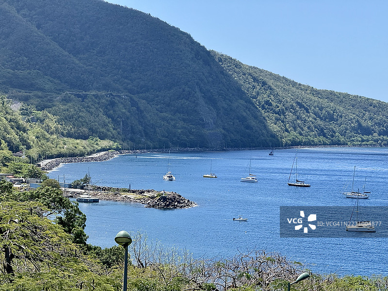 风景如画的海湾景观，帆船与郁郁葱葱的绿色山丘，古尔贝尔，瓜德罗普图片素材