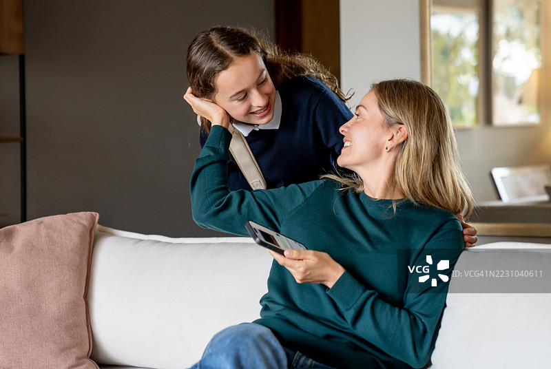 放学回家后，少女向母亲问好图片素材