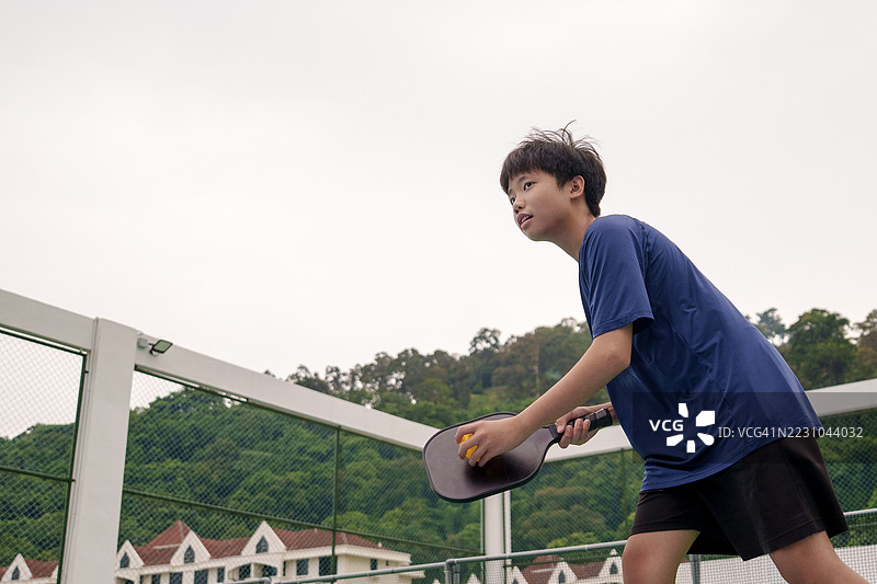 年轻球员在户外场地练习皮克球图片素材