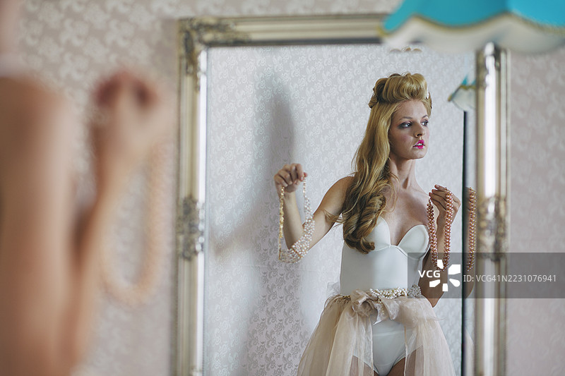 美丽的新娘在准备婚纱时决定佩戴珍珠项链图片素材