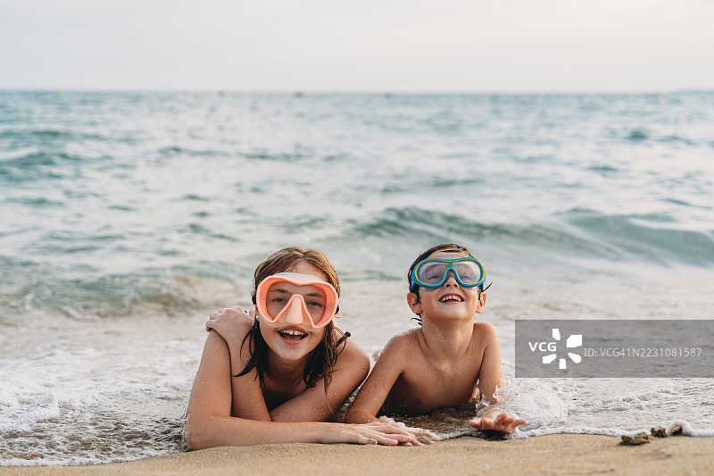 孩子们戴着潜水面具躺在沙滩上图片素材