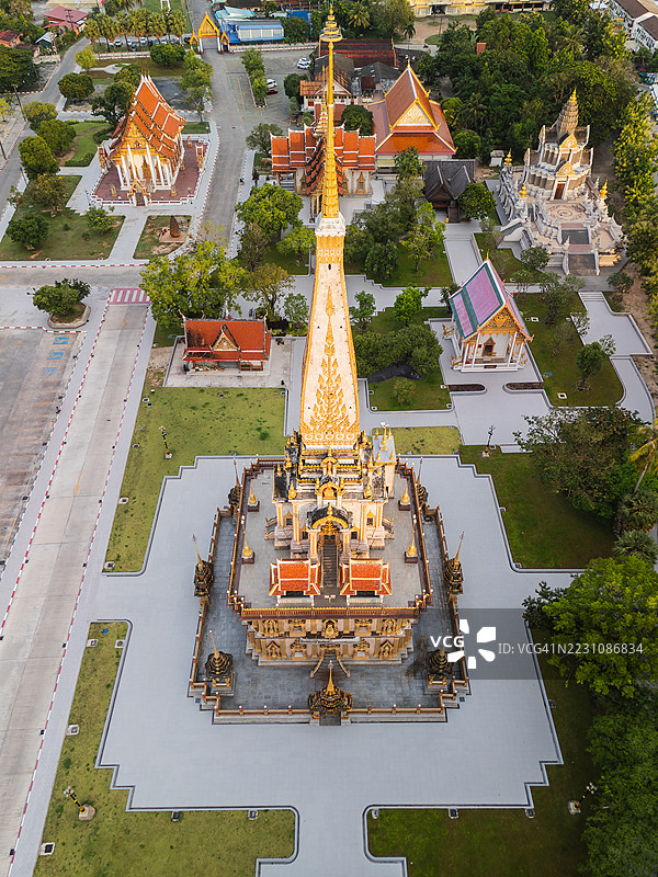 从空中俯瞰泰国普吉岛的查龙寺华丽的金色佛塔，周围环绕着寺庙建筑、绿树和步道。图片素材