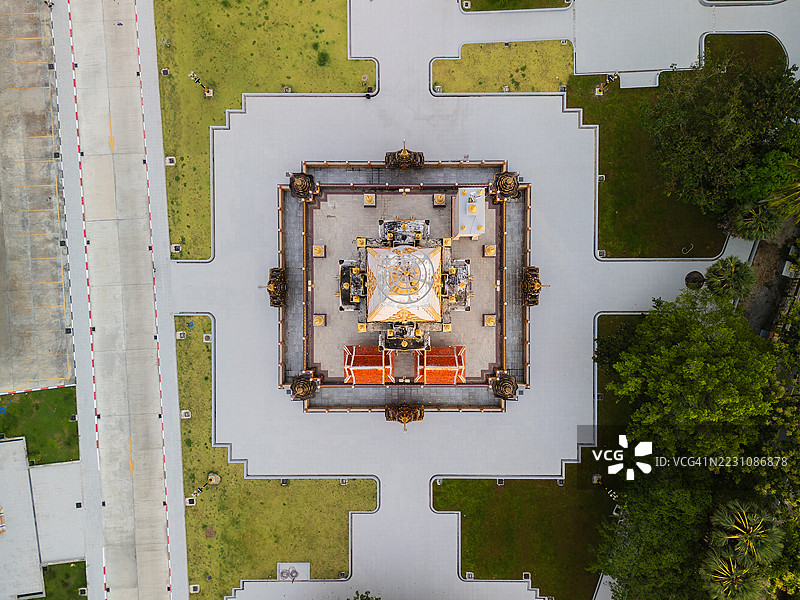 从空中俯瞰的无人机镜头，展示了被郁郁葱葱的绿树和山脉环绕的泰国装饰性寺庙，捕捉到普吉岛宁静的精神氛围。图片素材