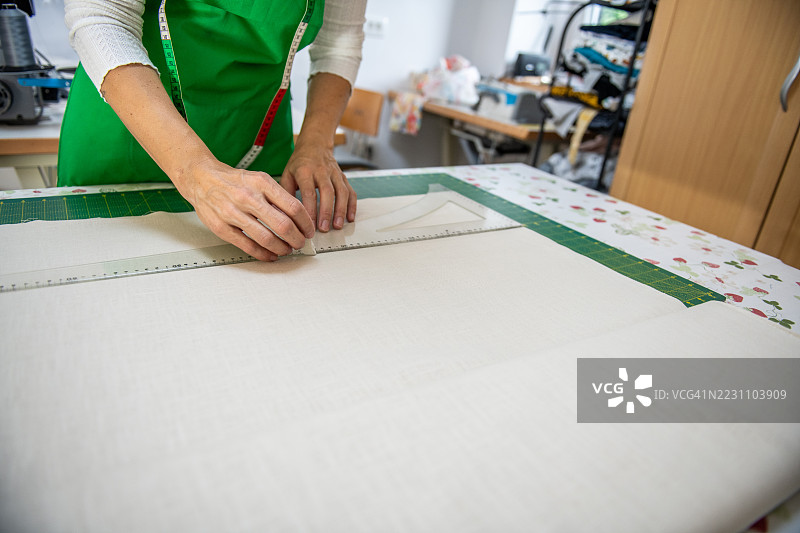 缝纫工作室里的女裁缝正在绘制服装图案图片素材