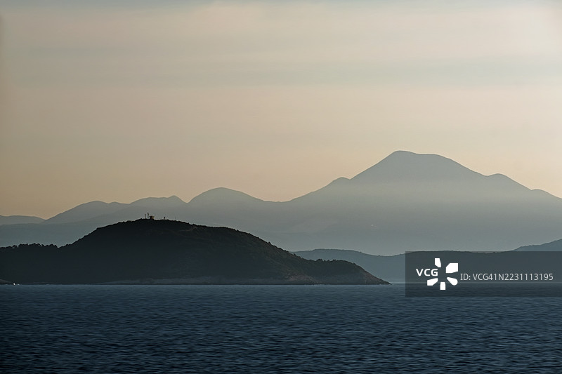 杜布罗夫尼克群岛和远处山脉的日出，伴随着壮观的云彩景观图片素材