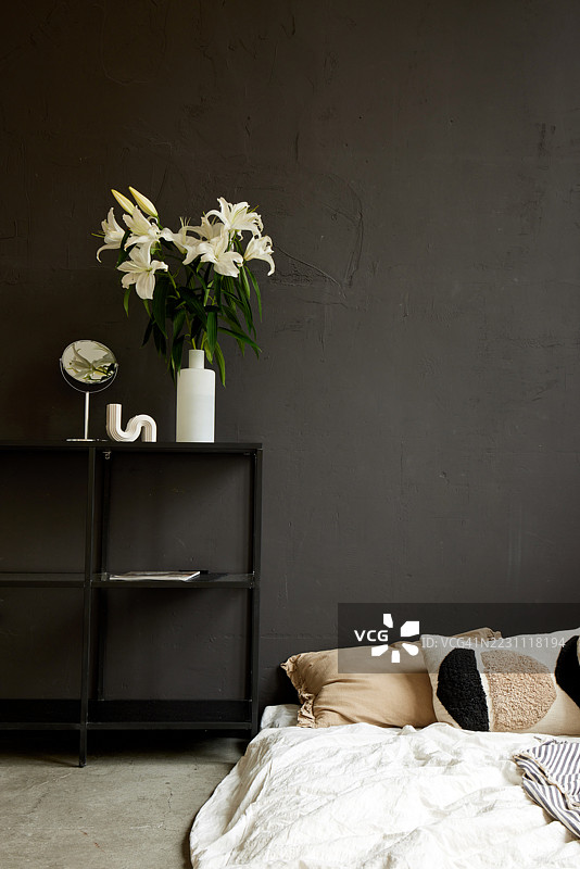 现代简约风格卧室室内，白色百合与深色背景墙相映成趣图片素材