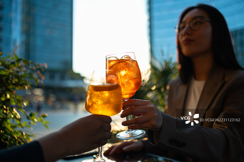 朋友们在意大利米兰举杯庆祝，享用阿佩罗尔斯普利茨。图片素材