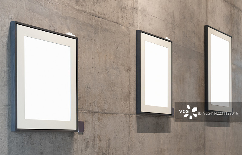 三幅空画框挂在混凝土墙上图片素材
